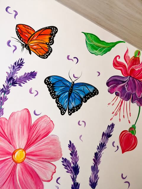Mural interior de mariposas y flores sobre pared blanca